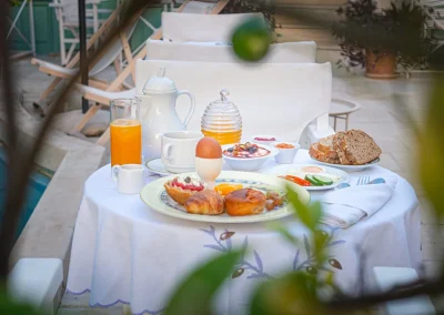 Greek breakfast table beside the courtyard pool at Mythos Suites Hotel