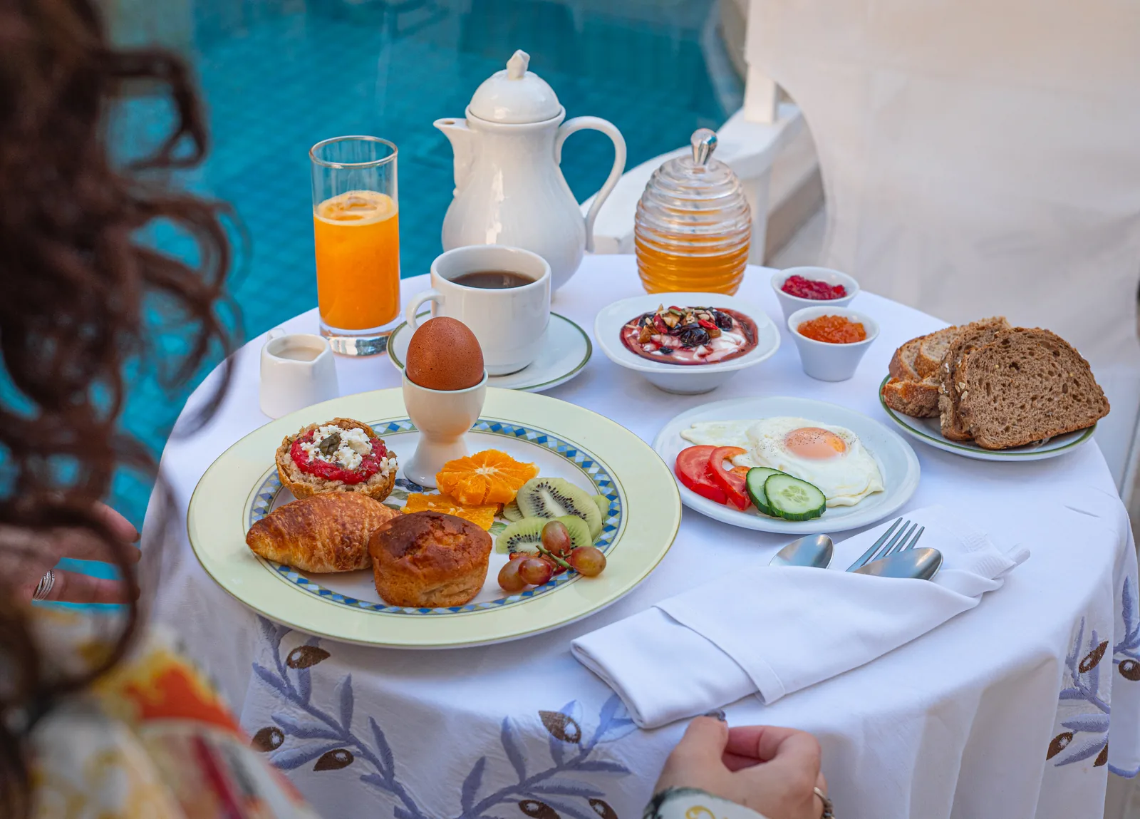Breakfast with coffee, orange juice and pastries by the Mythos courtyard pool